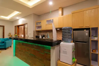 a kitchen with a black counter and a refrigerator at Sudha Villa Bali A in Seminyak
