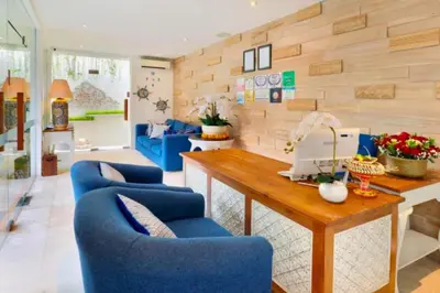 a living room with blue chairs and a wooden table at Romantic 1 BR Villa with Private Pool in Seminyak