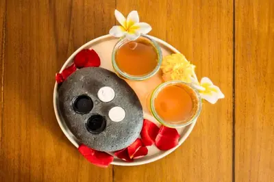 a plate of food with two glasses of tea and flowers at Romantic 1 BR Villa with Private Pool in Seminyak