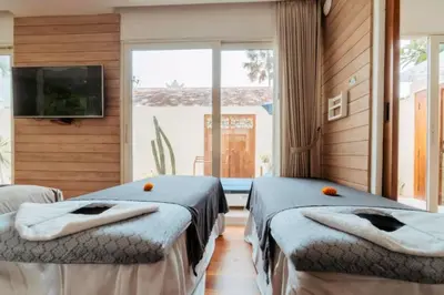 two beds in a room with a large window at Romantic 1 BR Villa with Private Pool in Seminyak