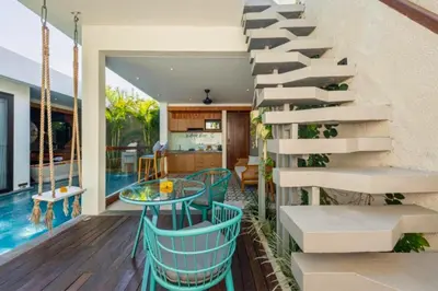 a staircase in a house with a table and a pool at Modern 1 BR Villa with Private Pool in Seminyak
