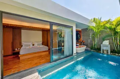 a bedroom with a bed and a swimming pool at Modern 1 BR Villa with Private Pool in Seminyak