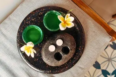 a plate with two green bowls and flowers on a table at Modern 1 BR Villa with Private Pool in Seminyak