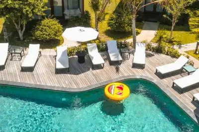 a pool with chairs and a frisbee in it at Luxury 1 BR Deluxe Twin Room in Canggu