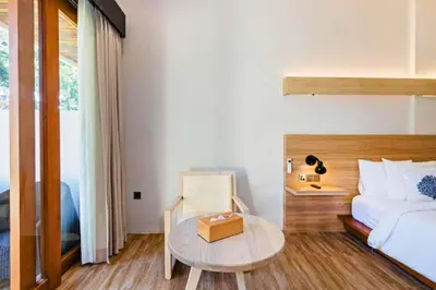 a bedroom with a bed and a table and a bed at Beautiful 1BR Deluxe Double Room in Canggu