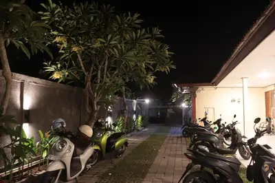 a row of scooters parked next to a building at night at Griya Mozaik in Jimbaran