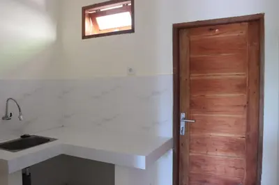 a kitchen with a sink and a wooden door at Griya Mozaik in Jimbaran