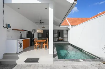 a kitchen and a house with a swimming pool at The Samsara Jimbaran Villa in Jimbaran