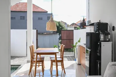 a kitchen with a table and chairs on a balcony at The Samsara Jimbaran Villa in Jimbaran
