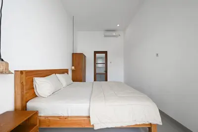 a bedroom with a bed with white sheets at The Samsara Jimbaran Villa in Jimbaran