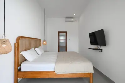 a bedroom with a bed and a flat screen tv at The Samsara Jimbaran Villa in Jimbaran