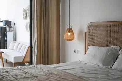 a bedroom with a bed and a pendant light at The Samsara Jimbaran Villa in Jimbaran