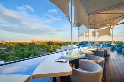 a restaurant with tables and chairs on a balcony at Antariksha 1 BR Superior Room in Seminyak