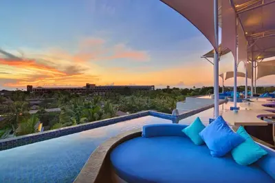 a pool with a blue couch and a sunset at Viorel 1 BR Whirlpool Suite Room in Seminyak