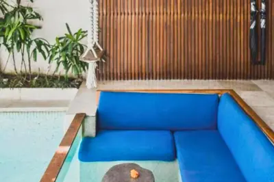 a blue couch in a room with a pool at Luxury 2 BR Villa with Private Pool & Bathtub in Seminyak