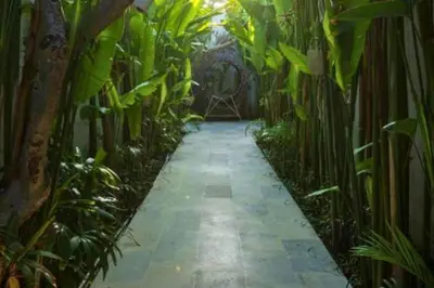 a walkway through a garden with plants at Entire 1 BR Villa With Private Pool in Seminyak