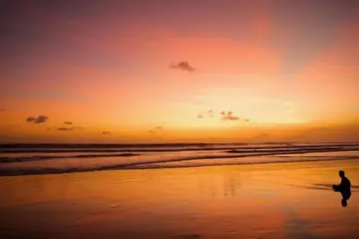 a person walking on the beach at sunset at Entire 1 BR Villa With Private Pool in Seminyak