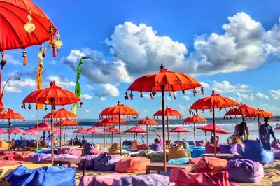 a bunch of red umbrellas on a beach at Entire 1 BR Villa With Private Pool in Seminyak