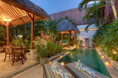 a resort with a pool and a table and chairs at Villa Petra Seminyak Bali in Seminyak
