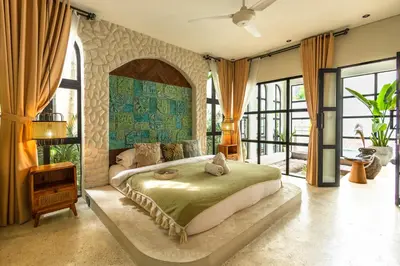 a bedroom with a large bed in a room with windows at Casa Toledo 1 Bedroom Seminyak - Kerobokan in Seminyak