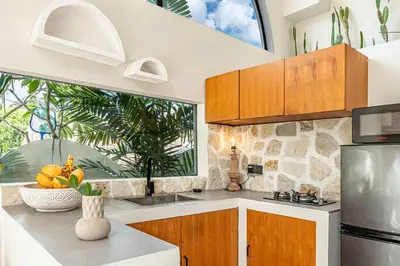 a kitchen with wooden cabinets and a large window at Casa Toledo 1 Bedroom Seminyak - Kerobokan in Seminyak