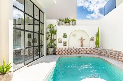 a swimming pool in a house with a cross on the wall at Casa Toledo 1 Bedroom Seminyak - Kerobokan in Seminyak
