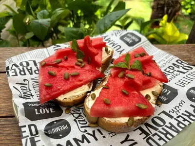 three sandwiches with watermelon on them on a newspaper at Villa Divna in Nusa Dua