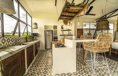a large kitchen with a counter and chairs in it at Villa Kosibali by Optimum Bali Villas in Kerobokan