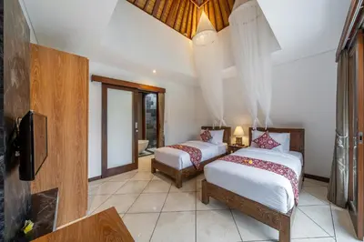 two beds in a room with a tv and a television at Villa MD 2 Stylish 3 BR w/ Sunny Pool at Prime Eat Street in Seminyak
