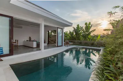 a swimming pool in a villa with a house at Gajah Villas Bali by Nagisa Bali in Seminyak