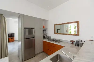 a kitchen with a stainless steel refrigerator and a mirror at Gajah Villas Bali by Nagisa Bali in Seminyak