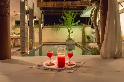 two glasses of red wine sitting on a table at Villa Club Corner Residence by Nagisa Bali in Canggu