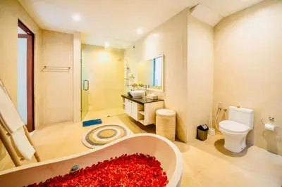 a bathroom with a bath tub filled with red flowers at Villa Julissa in Seminyak