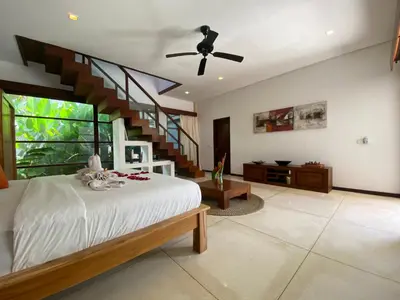 a bedroom with a bed with a staircase in it at Spacious Villa in Petitenget Top Location in Seminyak