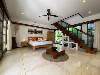 a bedroom with a bed and a staircase at Spacious Villa in Petitenget Top Location in Seminyak
