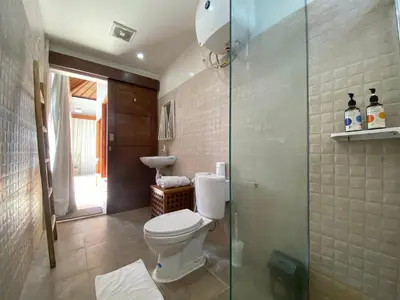 a bathroom with a toilet and a glass shower at Spacious Villa in Petitenget Top Location in Seminyak