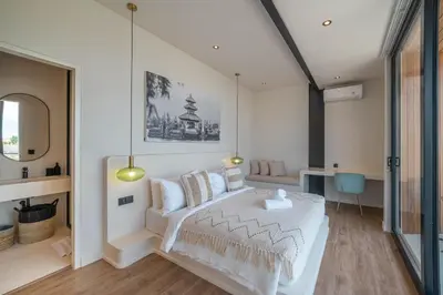 a bedroom with a white bed and a table at Villa Maverick - Brand New Classy 4BR Villa in Canggu in Canggu
