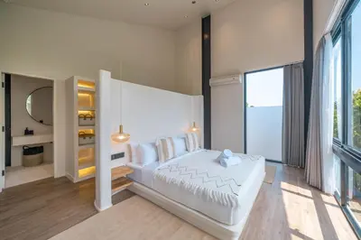 a bedroom with a white bed and a large window at Villa Maverick - Brand New Classy 4BR Villa in Canggu in Canggu