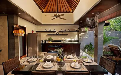 a dining room with a table and a kitchen at Villa MD Tranquil 6BR Villa at Eat Street in Seminyak