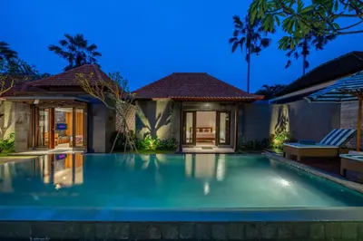 a villa with a swimming pool at night at Villa MD Tranquil 6BR Villa at Eat Street in Seminyak