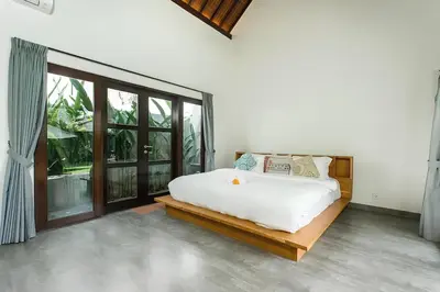 a bedroom with a white bed and a large window at Villa GrandLux Bali 2 Bed Villa Pool Big Garden in Seminyak