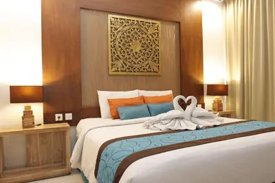 a bedroom with a large bed with towels on it at Destiny Boutique Hotel in Seminyak
