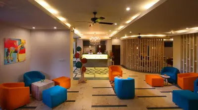 a lobby with orange and blue chairs and a bar at Destiny Boutique Hotel in Seminyak
