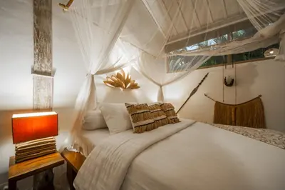 a bedroom with a white bed and a lamp at Villa Adagian - Magical 3BR Villa in Umalas in Canggu
