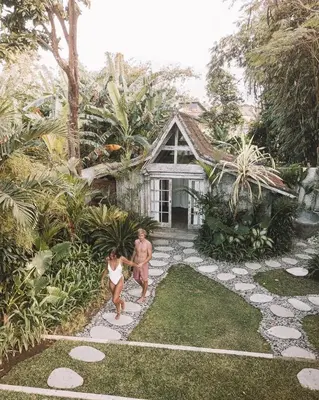 a man and a woman standing in front of a house at Villa Adagian - Magical 3BR Villa in Umalas in Canggu