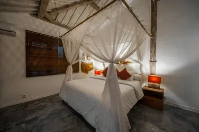 a bedroom with a bed with a mosquito net at Villa Adagian - Magical 3BR Villa in Umalas in Canggu