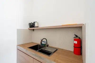 a kitchen with a sink and a red fire extinguisher at Villa Arawan - Beautiful 3BR Villa in Kerobokan in Kerobokan