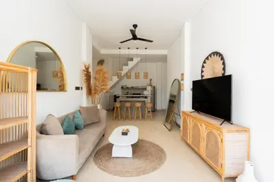 a living room with a couch and a tv at Villa Arawan - Beautiful 3BR Villa in Kerobokan in Kerobokan