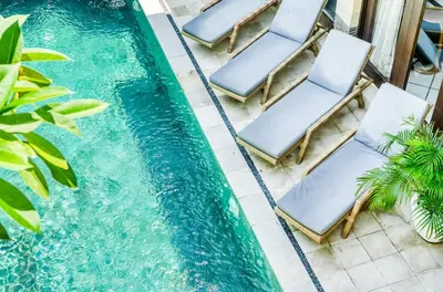 an overhead view of chairs and a swimming pool at Virginia villa 4BR 5min walk to beach with assistant villa and pick up from airport and security in Canggu