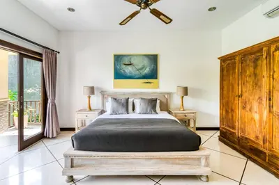 a bedroom with a bed and a ceiling fan at Virginia villa 4BR 5min walk to beach with assistant villa and pick up from airport and security in Canggu